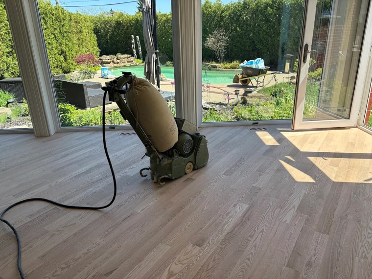 Dustless floor sander resurfacing a solid oak floor
